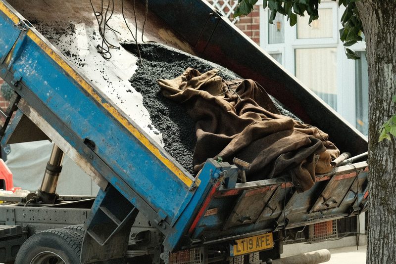 Malý sklápěč do 3,5 t vysypává písek na dvoře rodinného domu
